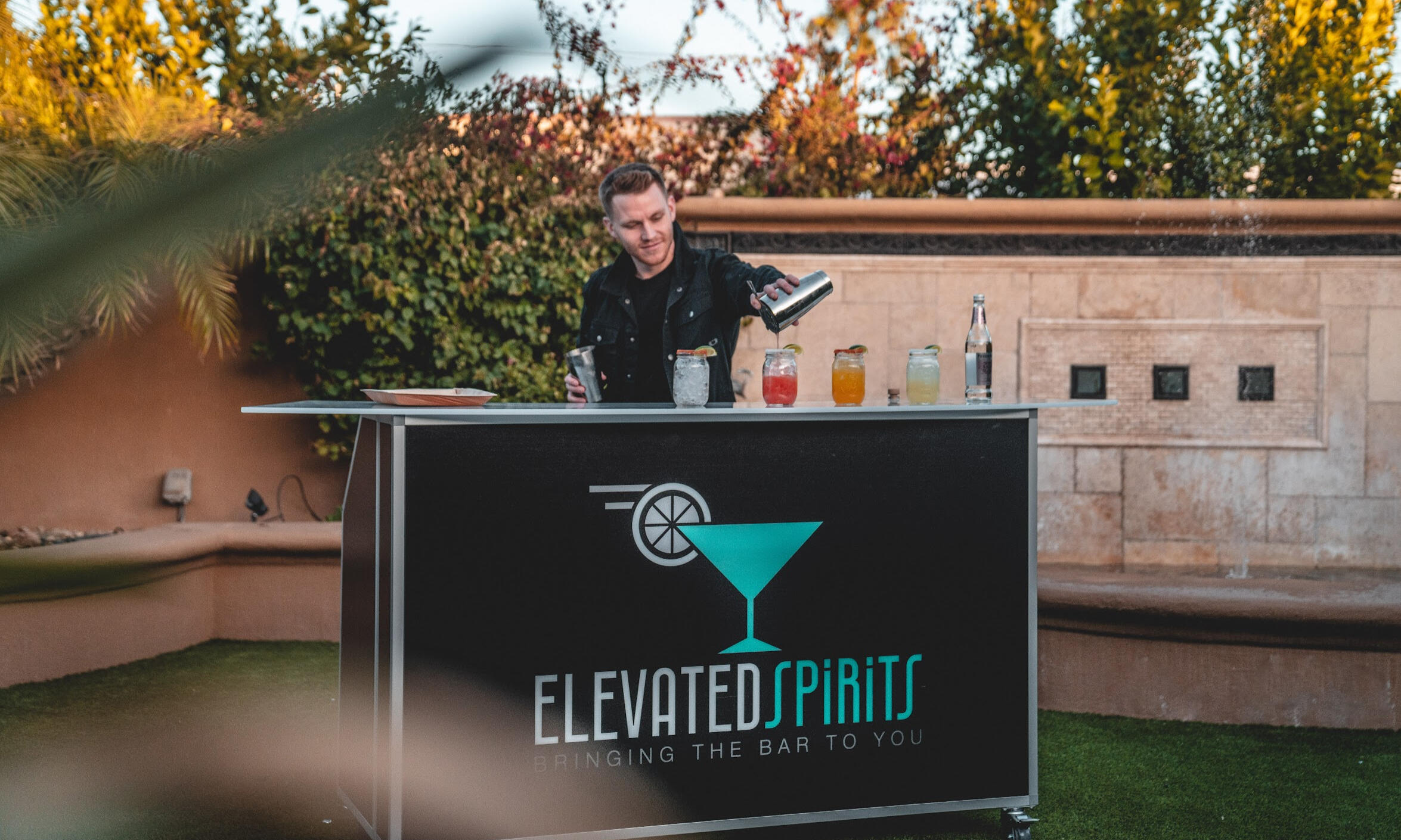 Elevated Spirits Portable Bar Setup Bartender serving drinks behind an Elevated Spirits portable bar at an outdoor event.