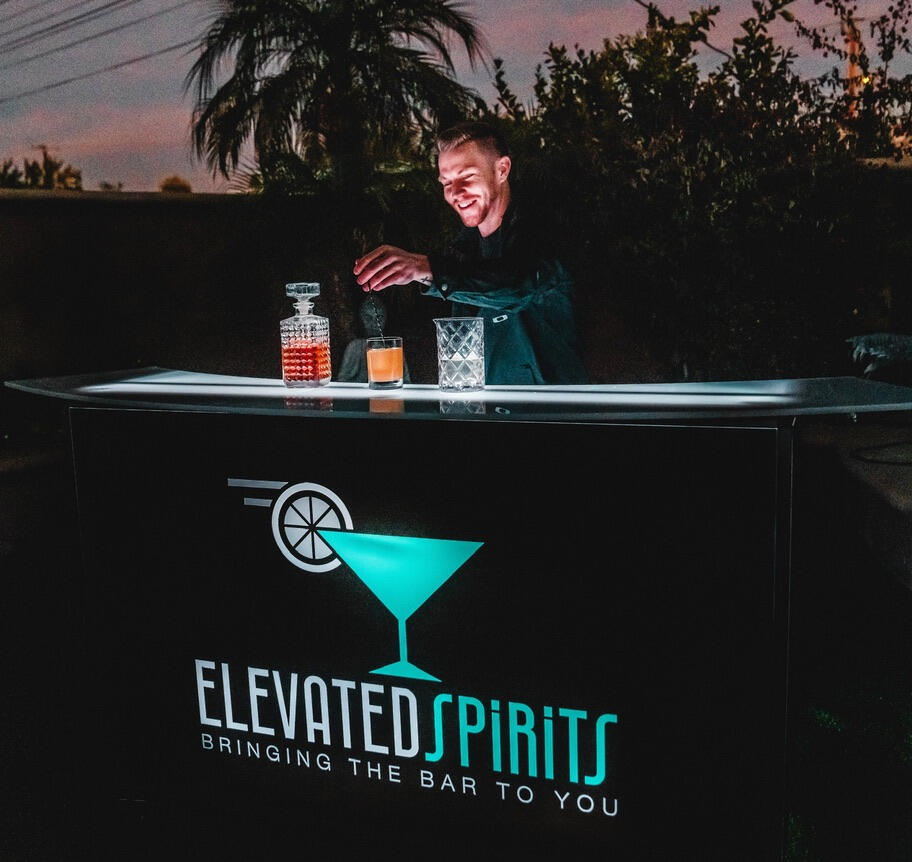 Mobile Bar Service in Phoenix Bartender serving cocktails from an Elevated Spirits mobile bar at an outdoor event.